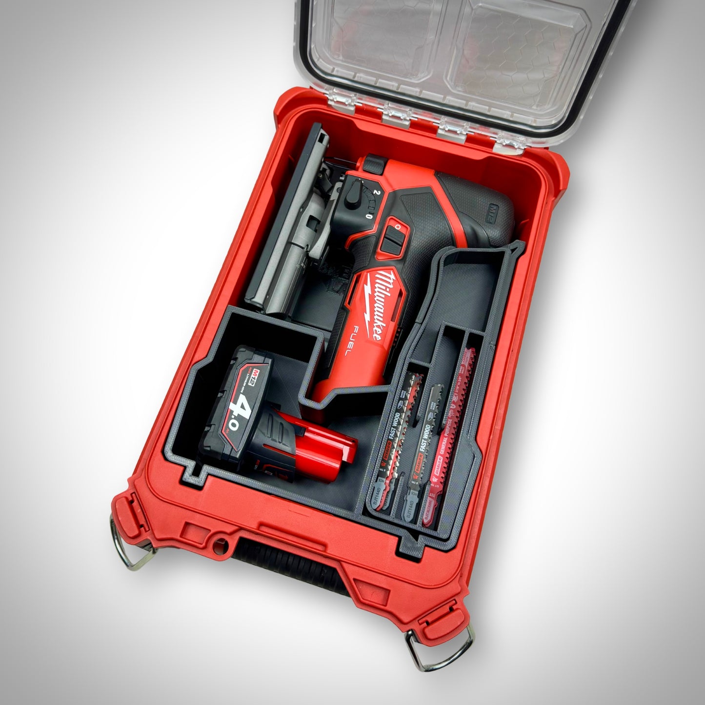 Milwaukee PACKOUT Compact Organiser with custom insert securely holding the M12 FUEL Jigsaw and accessories, all neatly arranged inside the container.