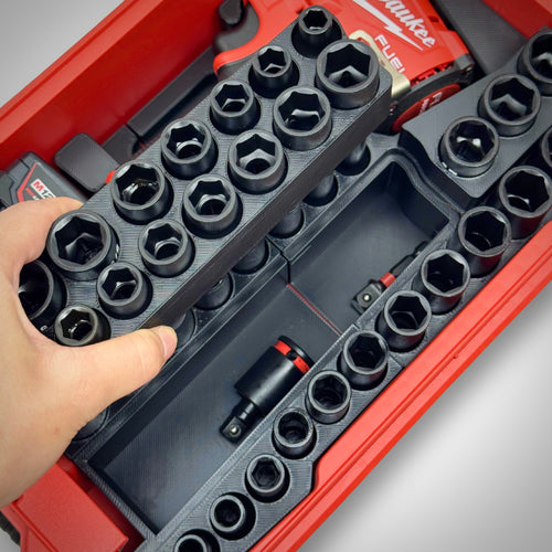 Hand lifting a removable socket rail from the insert, exposing hidden storage space below inside the PACKOUT™ Compact Organiser.