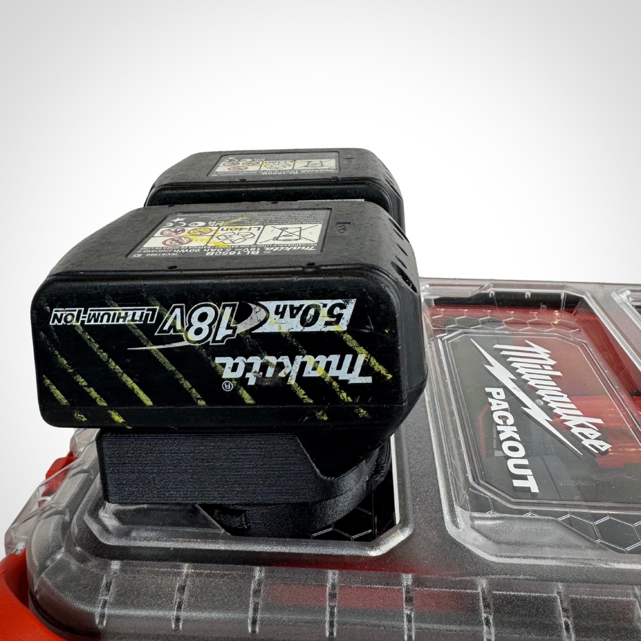 Makita 18V batteries securely slotted into the adaptor insert, ready for transport or use.