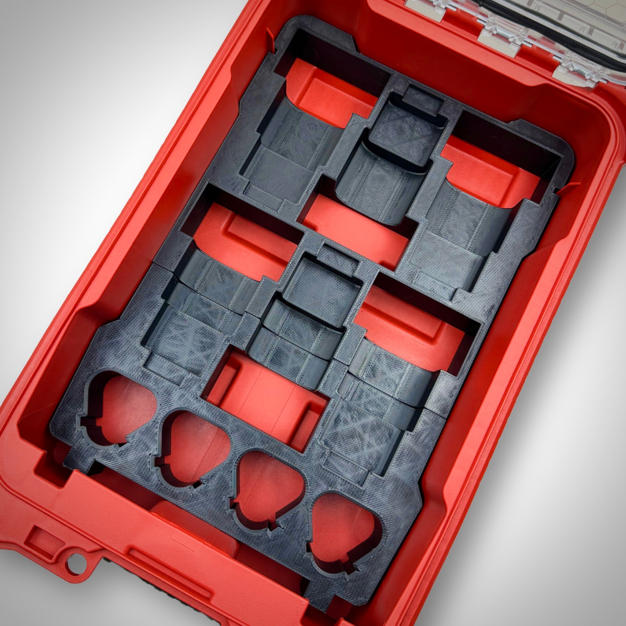 Empty black M12 Battery Storage Insert securely fitted inside the Milwaukee PACKOUT™ Compact Organiser, ready to hold M12 batteries.