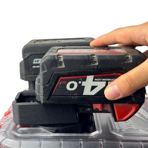 A hand removes an M18 battery from the insert, demonstrating smooth and easy access