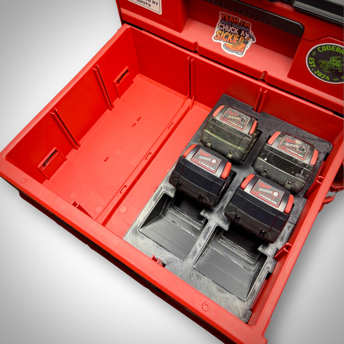 Top-down view of the M18 Battery Storage Insert securely fitted in the Milwaukee PACKOUT™ Two-Drawer Toolbox, holding four M18 batteries neatly in place.