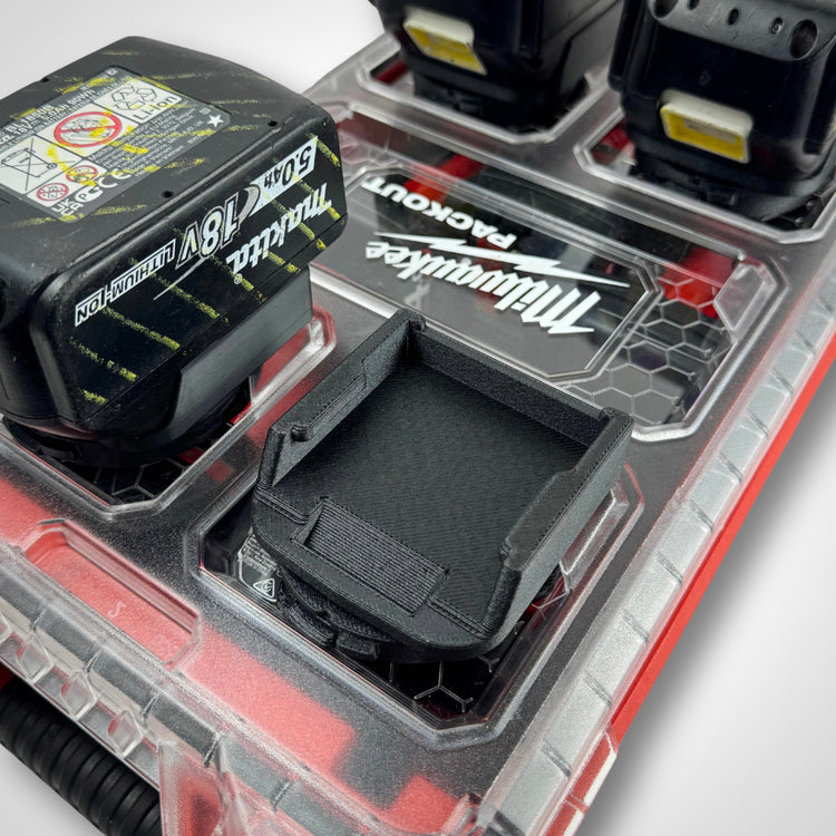 Makita 18V battery adaptor insert placed on top of the PACKOUT™ Compact Organiser, completely empty and showcasing internal slots.