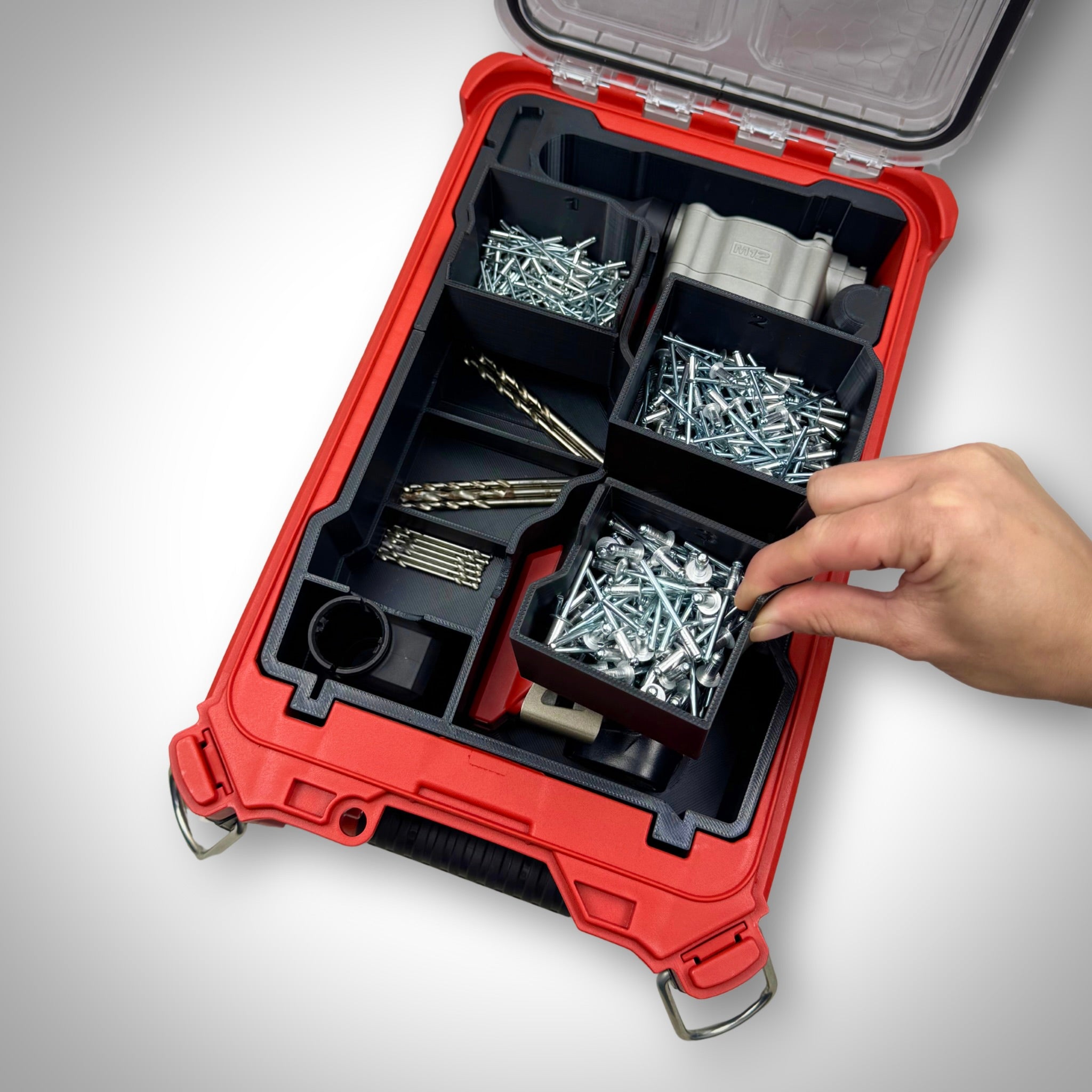 Milwaukee PACKOUT insert fully loaded with a ratchet, bolts, and small parts containers—demonstrating the included compartments, ready-to-use setup for efficient on-site organisation
