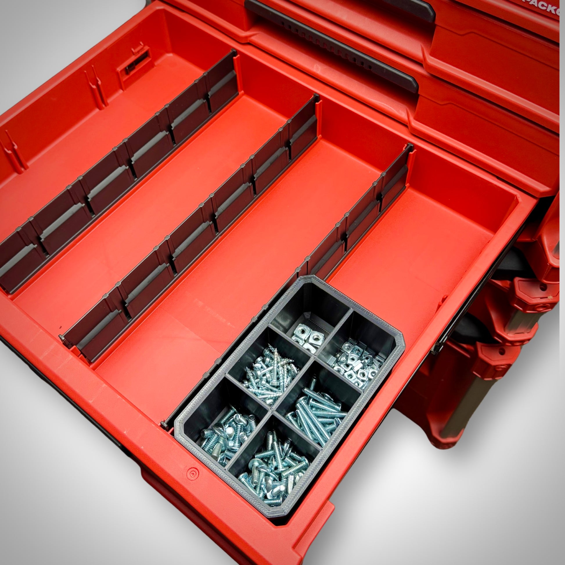 Milwaukee PACKOUT™ 6-Way Divider Bin fully loaded with screws, bits, and tiny gear, secured inside the 4-Drawer Toolbox.