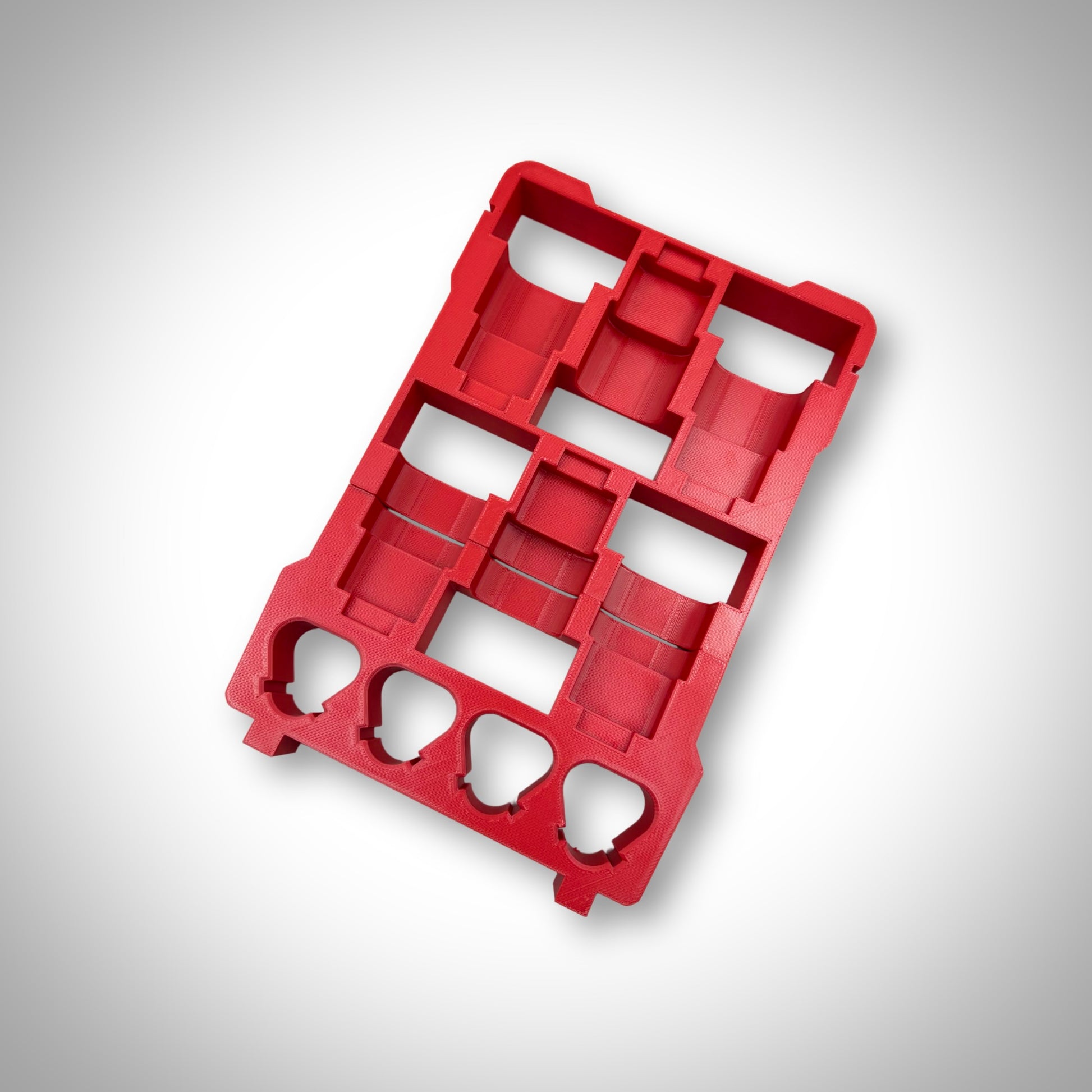 Empty red M12 Battery Storage Insert displayed outside the Milwaukee PACKOUT™ Compact Organiser, highlighting its sturdy design and perfect fit.