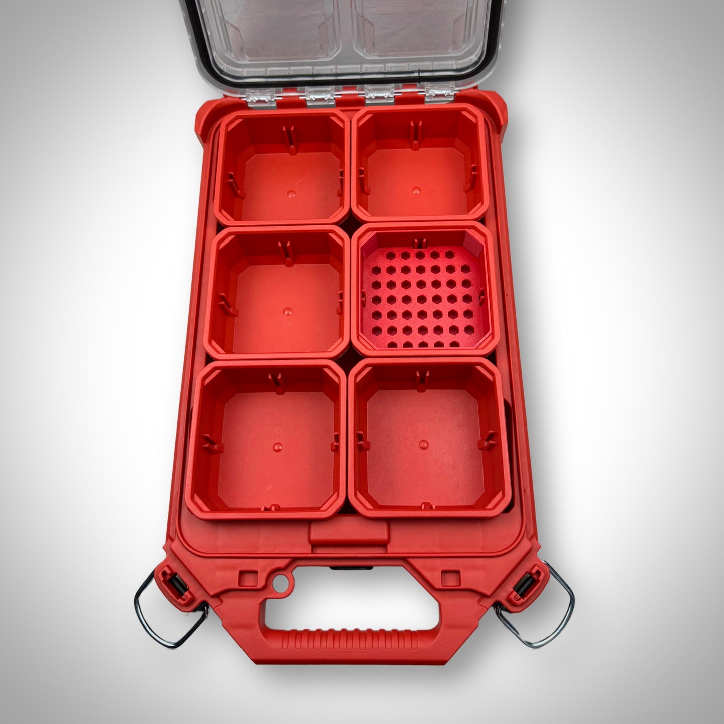 Empty red Low-Profile Bit Holder Insert placed inside a Milwaukee PACKOUT™ bin, highlighting its slim design and bit compartments.