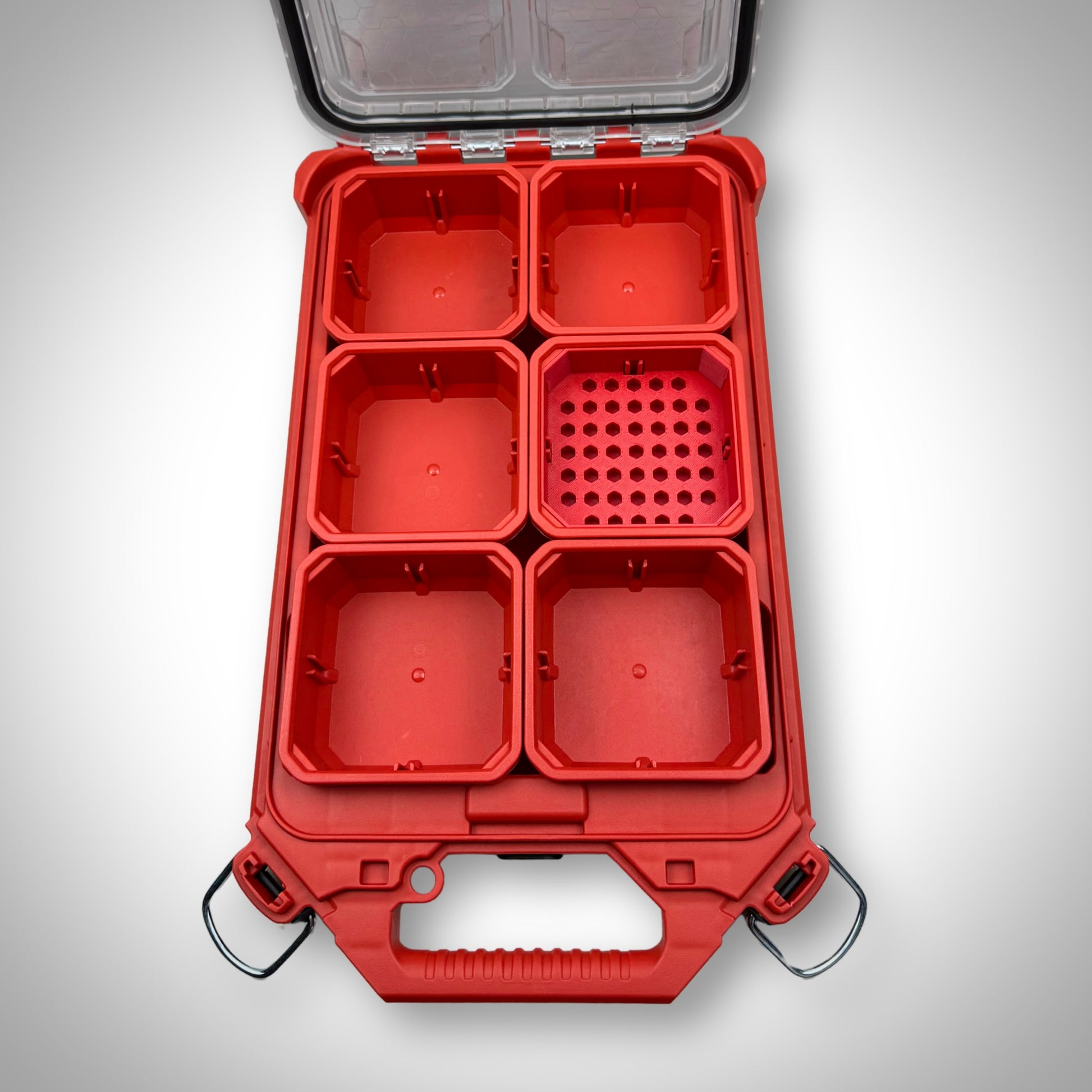 Empty red Low-Profile Bit Holder Insert placed inside a Milwaukee PACKOUT™ bin, highlighting its slim design and bit compartments.