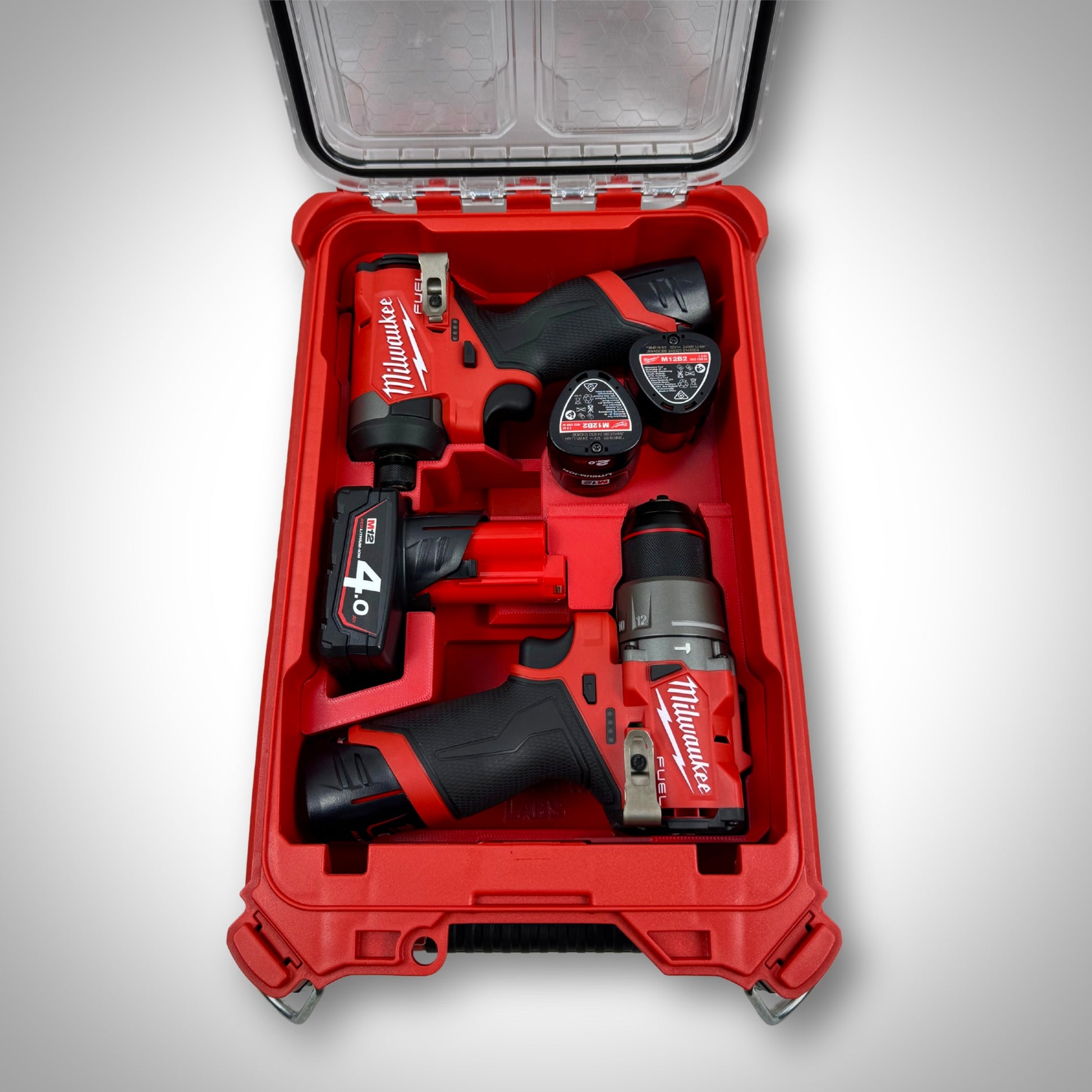 Red custom insert in PACKOUT™ Compact Organiser holding the M12 Hammer Drill, M12 Impact Driver, batteries, and bits neatly in place.