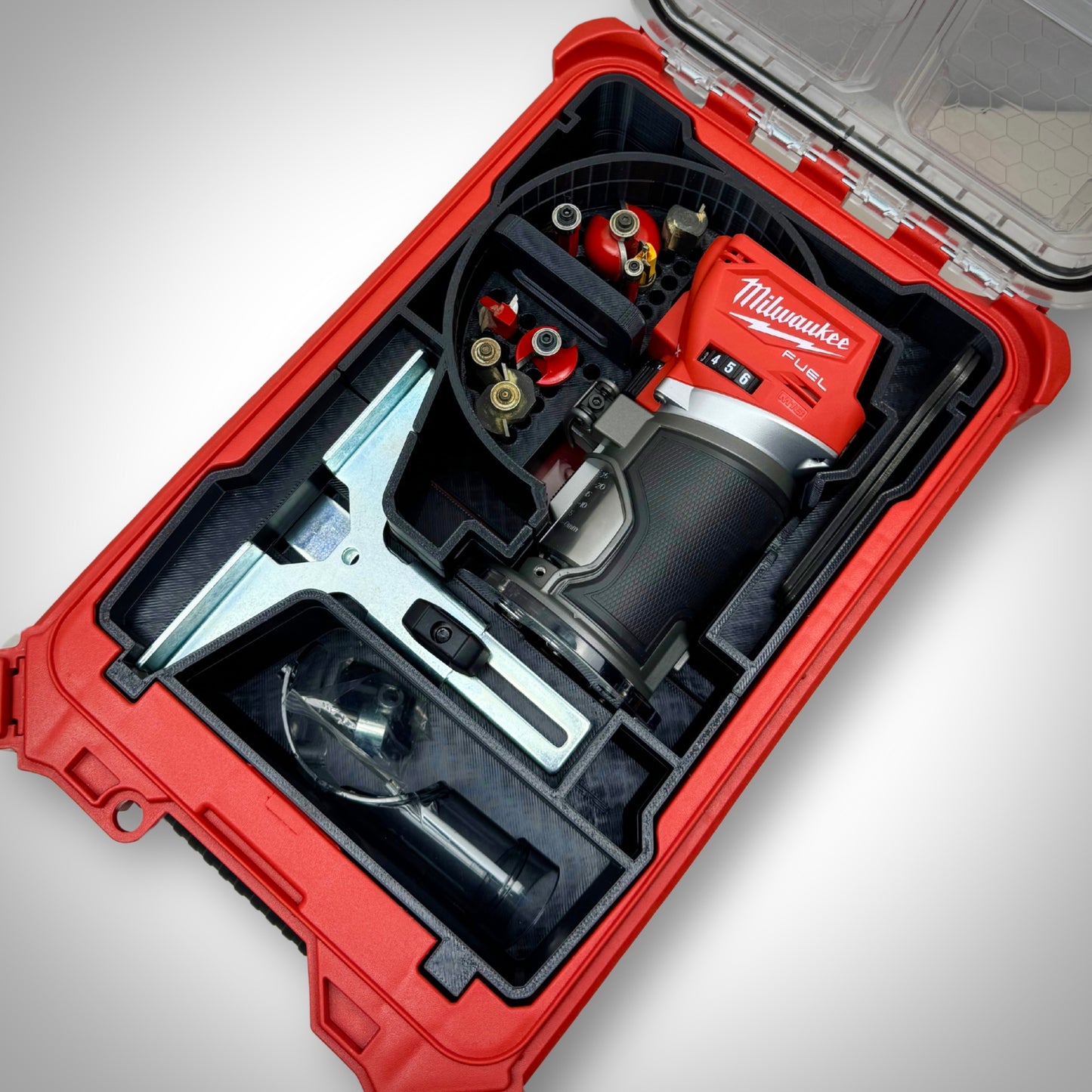 M18 Compact Router, edge guide, base plates, and accessories neatly arranged in the insert inside the Milwaukee PACKOUT™ Compact Organiser.