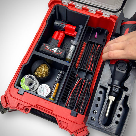 Hand lifting the layered container from the loaded M12 Soldering Iron Insert inside the PACKOUT™ Compact Organiser revealing more storage underneath, showing quick and easy access on-site.
