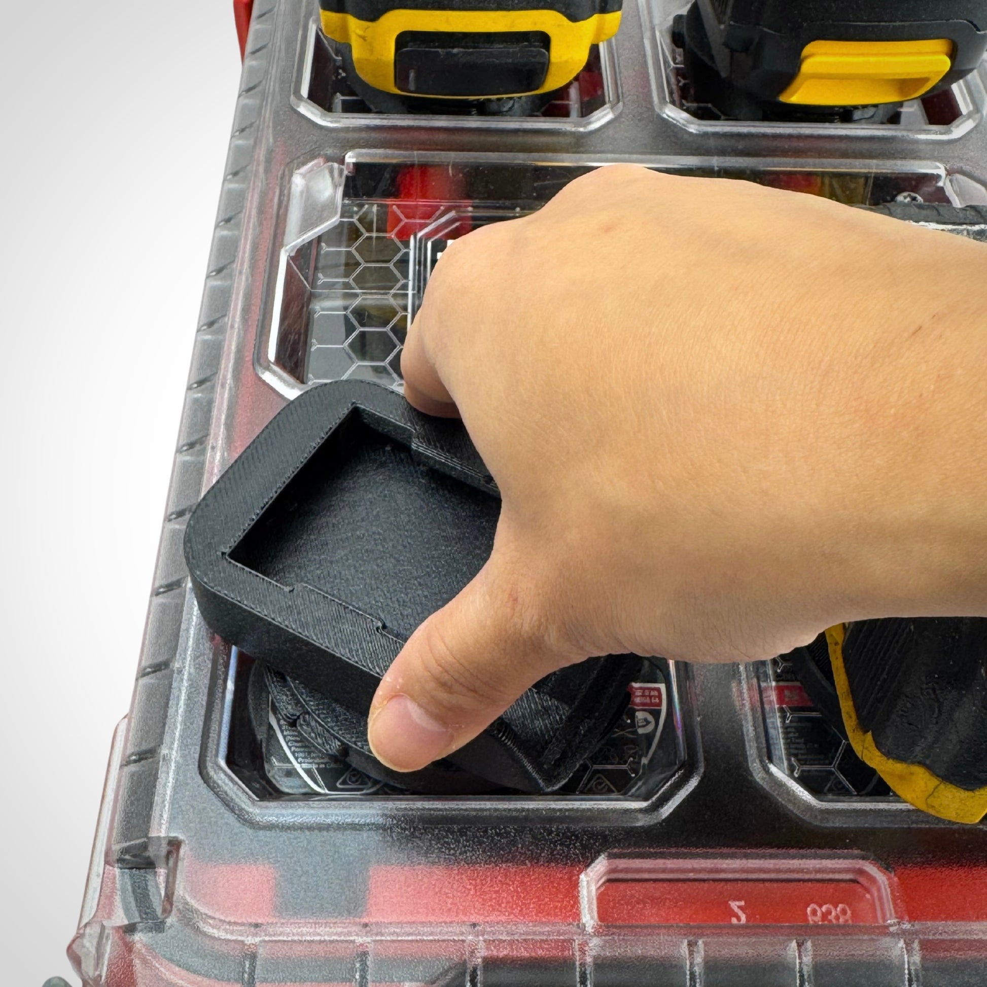 A hand twisting the adaptor in place ontop of the Milwaukee PACKOUT organizer