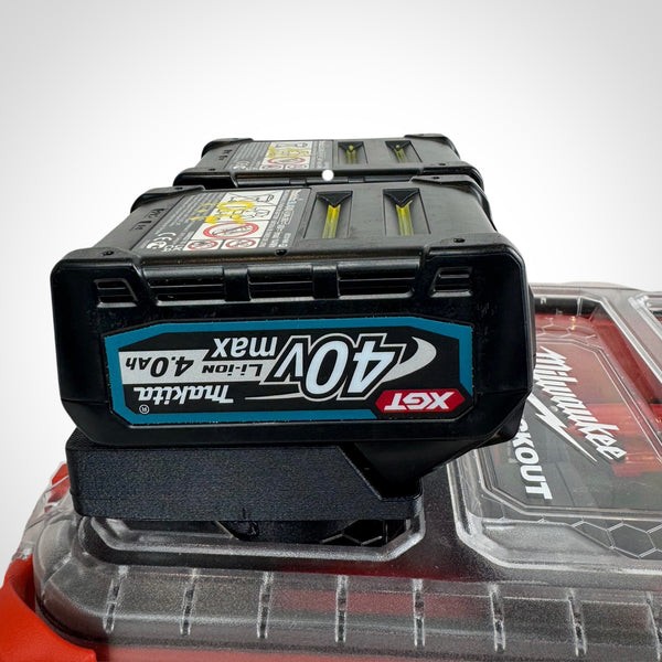 Makita 40V batteries neatly secured in the adaptor insert atop a Milwaukee PACKOUT™ Compact Organiser, showcasing snug compatibility.