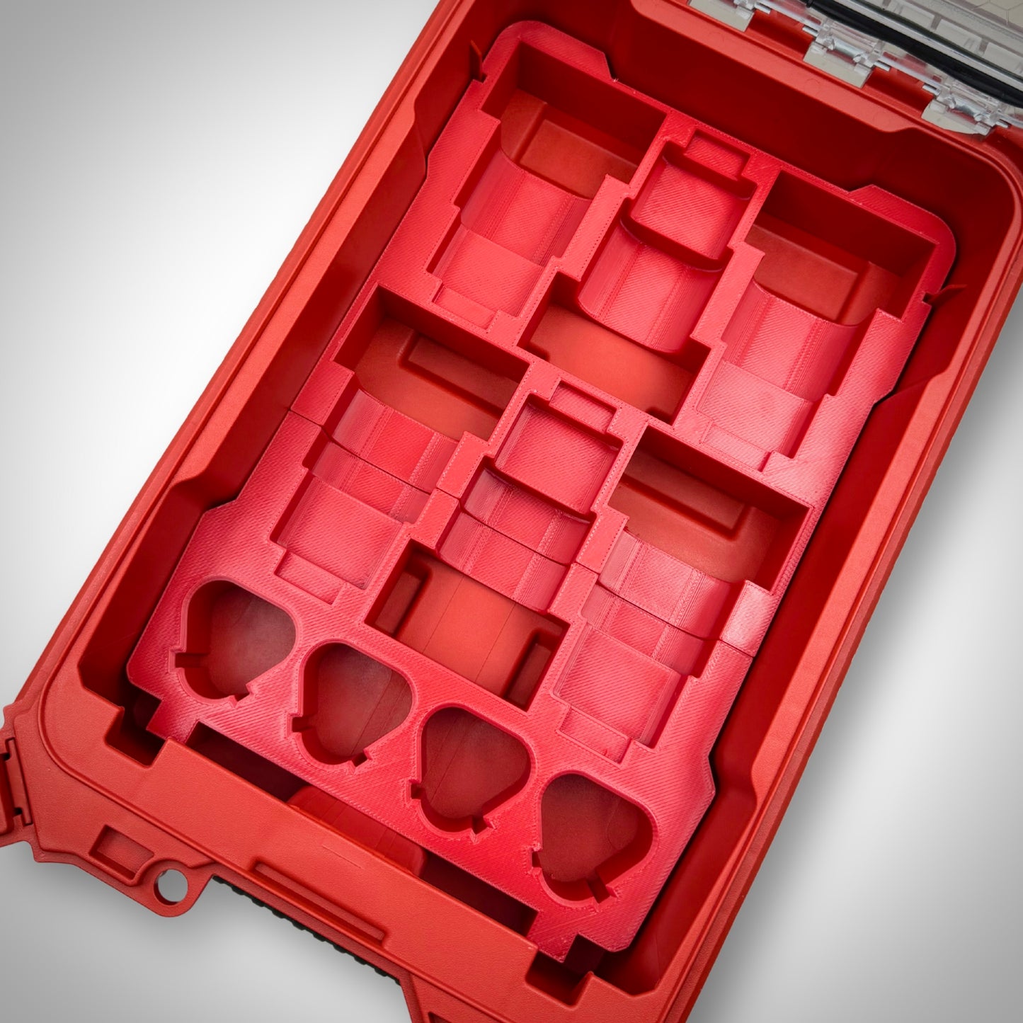 Empty red M12 Battery Storage Insert securely fitted inside the Milwaukee PACKOUT™ Compact Organiser, ready to hold M12 batteries.