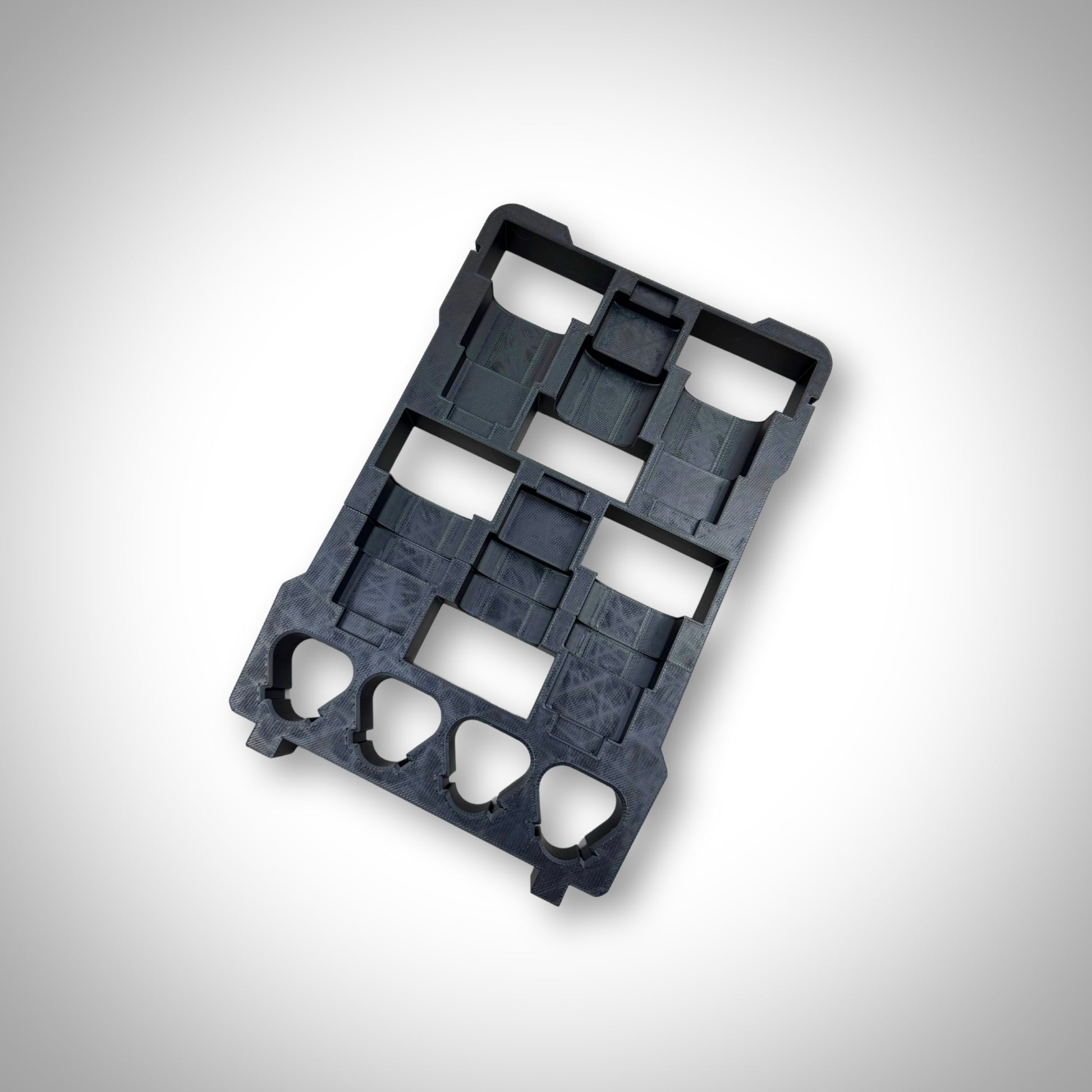 Empty black M12 Battery Storage Insert displayed outside the Milwaukee PACKOUT™ Compact Organiser, highlighting its sturdy design and perfect fit.