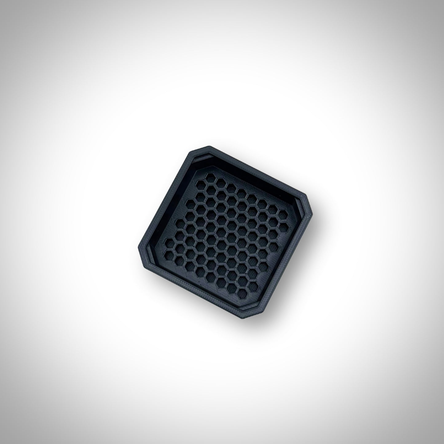 Black Hex Bit Holder insert outside a Milwaukee PACKOUT™ bin, showcasing the bit slots and sturdy construction.