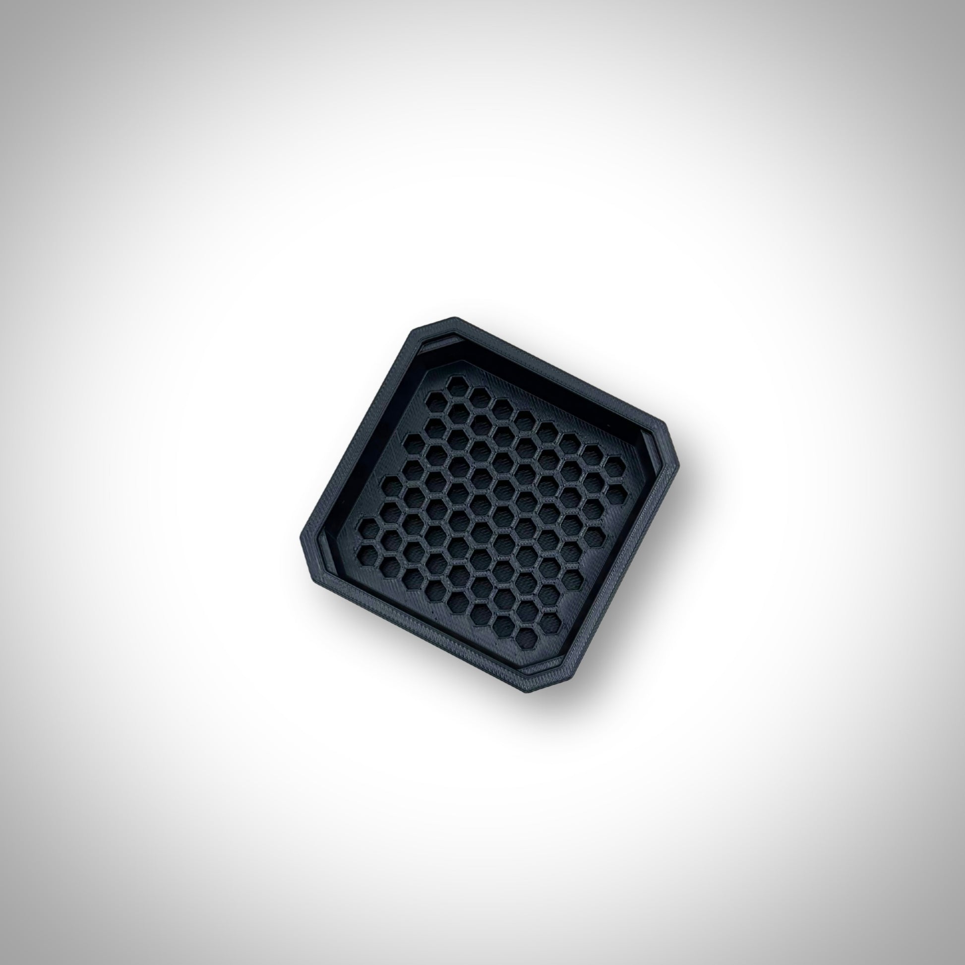 Black Hex Bit Holder insert outside a Milwaukee PACKOUT™ bin, showcasing the bit slots and sturdy construction.