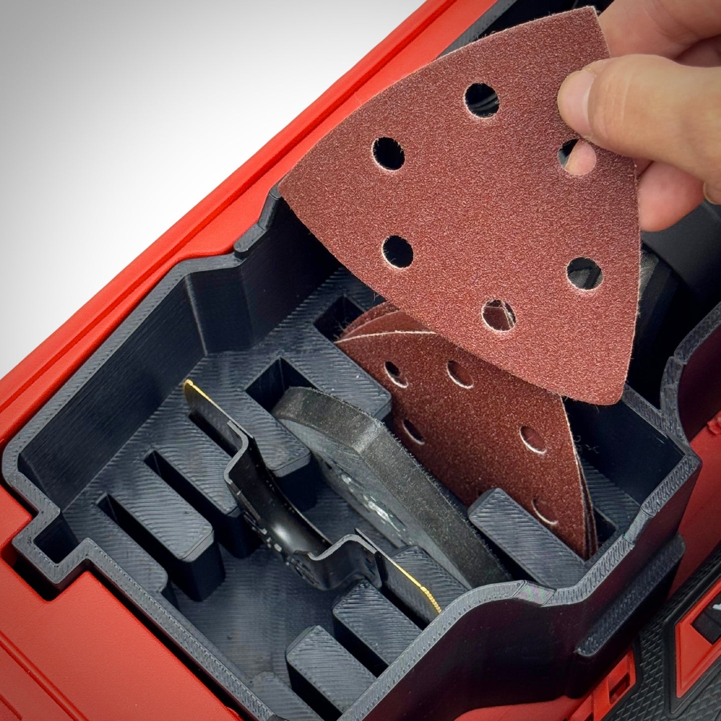 Hand lifting an accessory from the insert, demonstrating quick access and organized storage of all included accessories.
