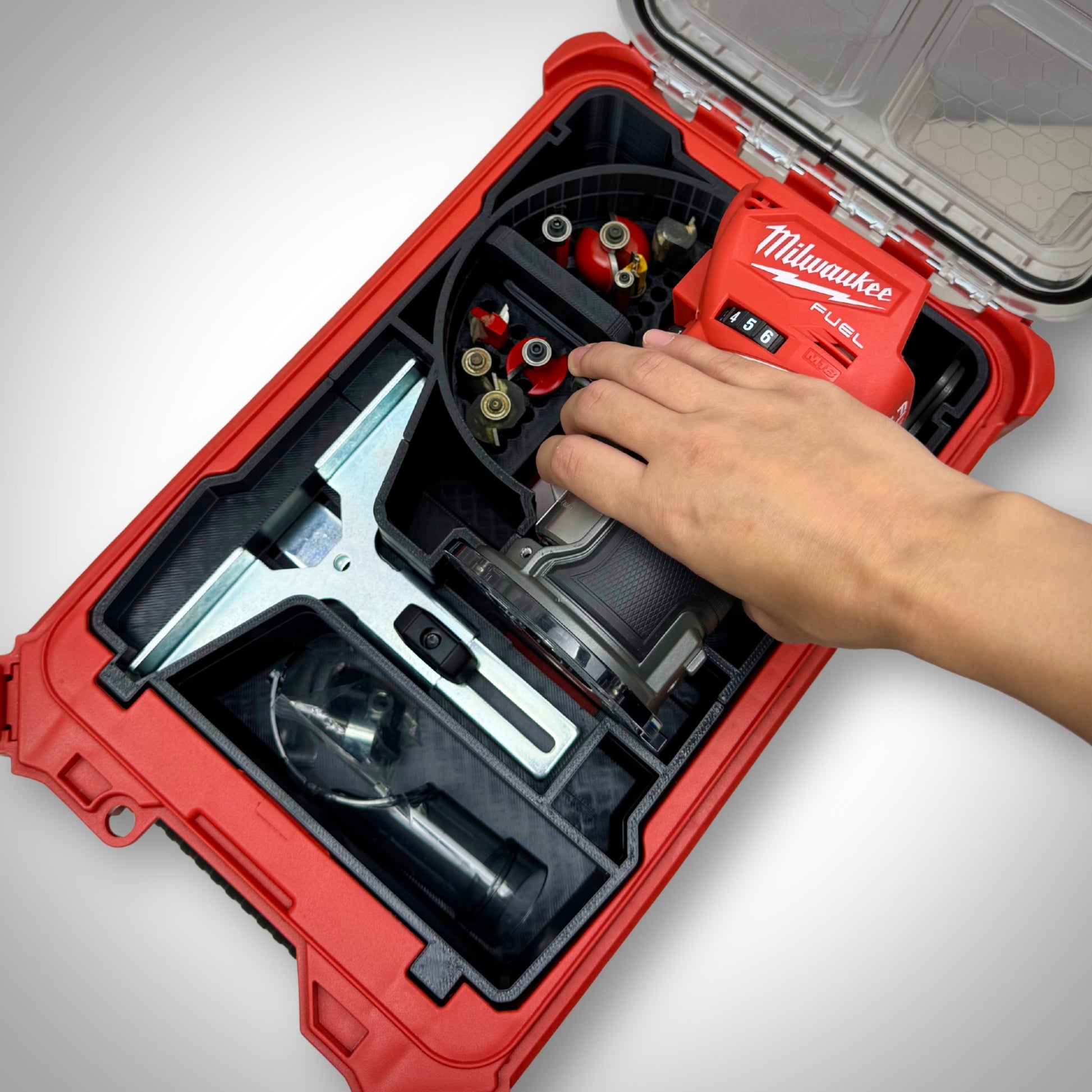 Hand lifting the M18 Compact Router from the insert, showing smooth access and well-organised accessory storage.