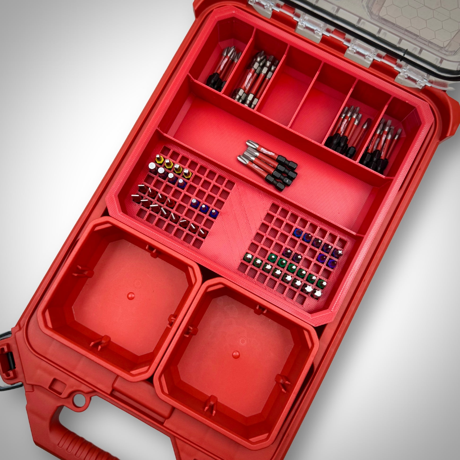 Milwaukee PACKOUT™ Low Profile Organiser featuring the red Impact Bit Holder V2 fully loaded with 50mm bits and extension bits, neatly arranged inside the toolbox.