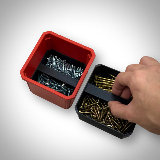 Hand lifting a double stack bin divider section filled with screws and hardware inside the Milwaukee PACKOUT™ Medium Organiser, demonstrating easy access to organised storage.