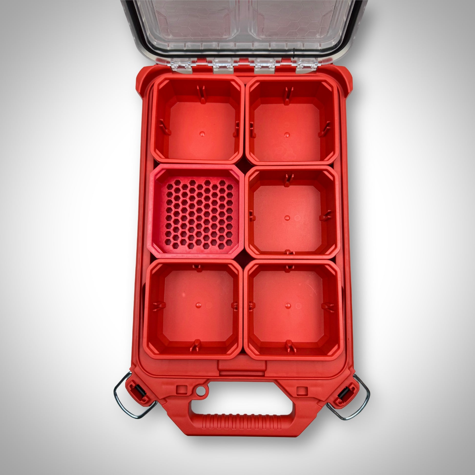 Empty red Hex Bit Holder insert installed inside a Milwaukee PACKOUT™ bin, showing slots for 76 hex bits.