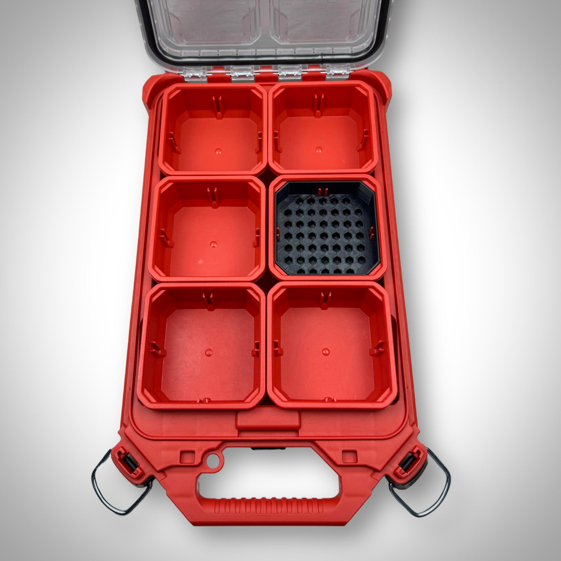 Empty black Low-Profile Bit Holder Insert fitted inside a Milwaukee PACKOUT™ bin, showing compartments for secure bit storage