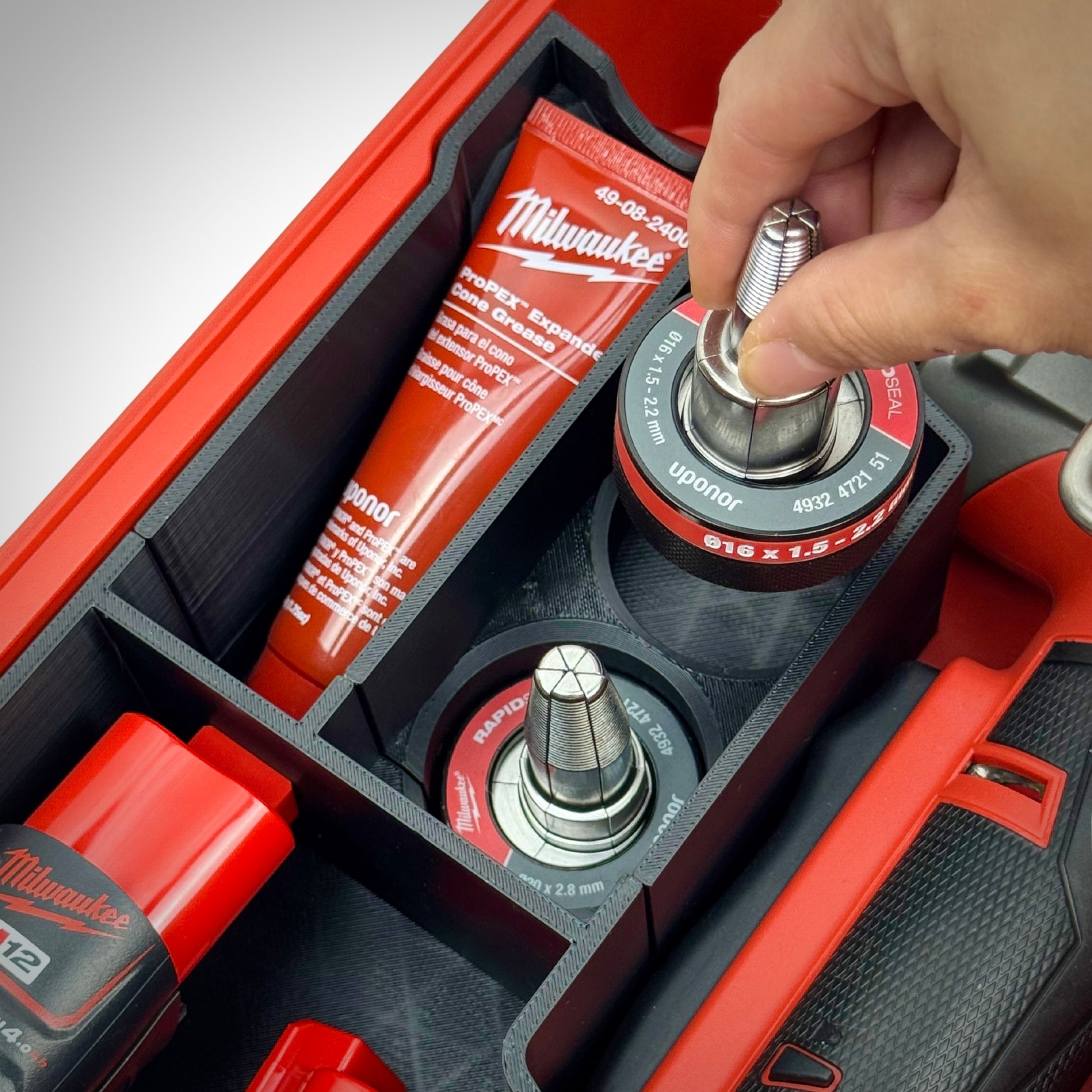 Hand lifting an accessory out of the insert, showing intuitive layout and convenient access to attachments.