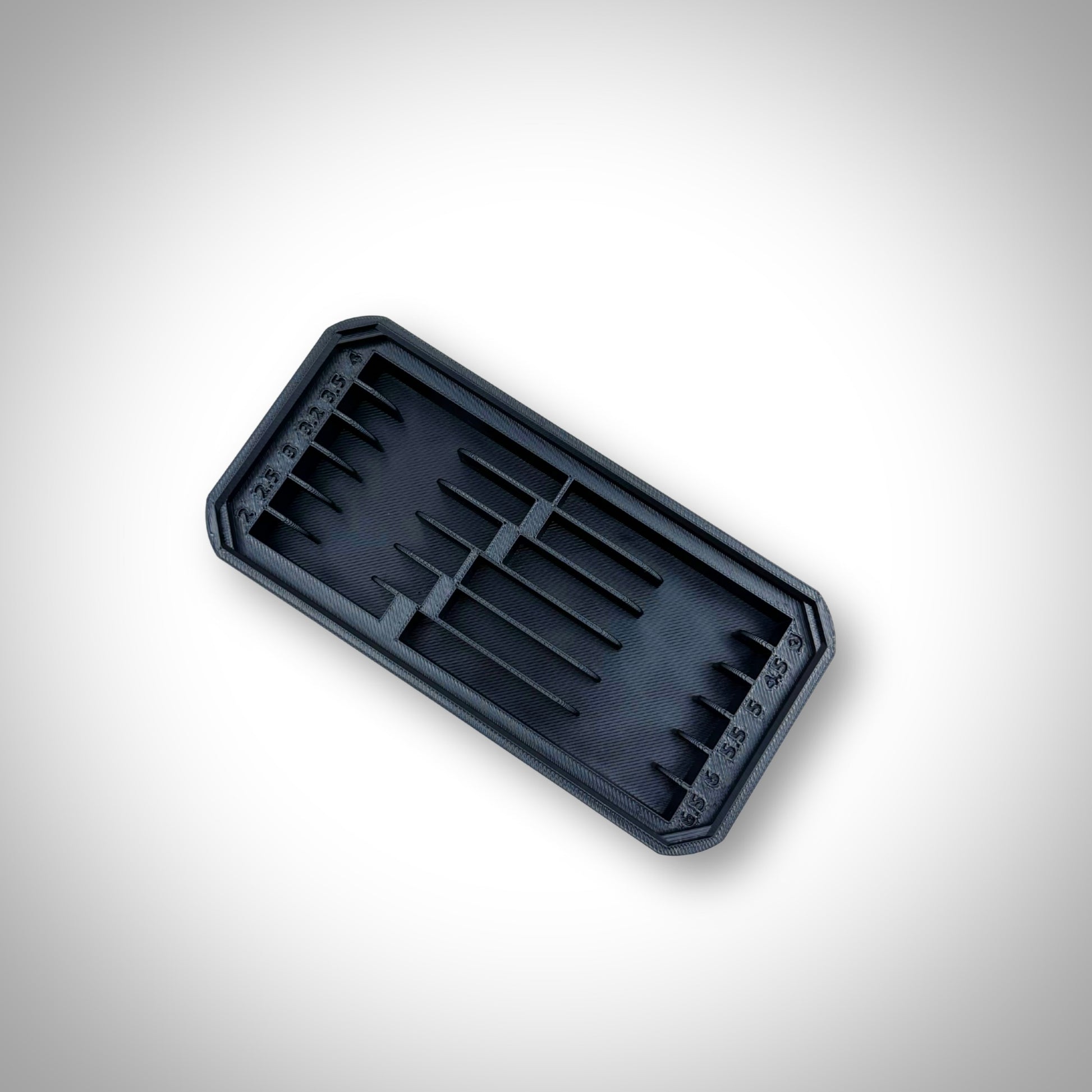 Empty black Metric Drill Bit Holder Insert displayed outside the Milwaukee PACKOUT™ Low Profile Organiser, highlighting its durable design and precision moulding.