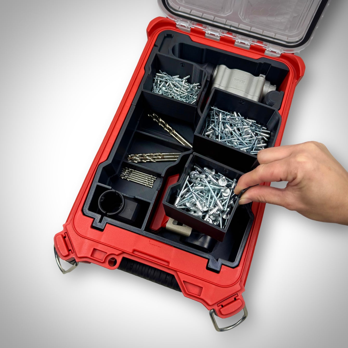 Milwaukee PACKOUT insert fully loaded with a ratchet, bolts, and small parts containers—demonstrating the included compartments, ready-to-use setup for efficient on-site organisation